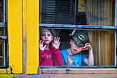Children looking through the window. The Yellow Train or Train Jaune, Pyrénées-Orientales, Languedoc-Roussillon, France.