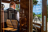 Fahrer der historischen Straßenbahn im Dorf Soller. Die Straßenbahn verkehrt auf einer Strecke von 5 km vom Bahnhof im Dorf Soller zum Puerto de Soller, Soller Mallorca, Balearen, Spanien, Mittelmeer, Europa
