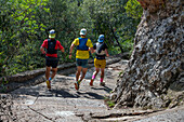 Montserrat, Catalonia, Barcelona Spain. People running on the way to the Cave Santa Cova De Montserrat Or Holy Cave Of Montserrat In Summer Day. Santa Maria De Montserrat Abbey.