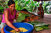 Woman preparing Juanes homemade corn and chicken tamales by traditional method in Timicuro I, Iqutios peruvian amazon, Loreto, Peru.