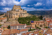 Aerial sunset view of Morella, medieval walled town with semi circular towers and gate houses crowed by a fortress on the rock in Spain, Valencia comunity, Castellon province.