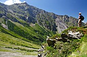 France, Isere, Lavaldens, Female hiker watching the Coiro summit, on the path toward Rif bruyant lake