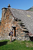 France, Isere, Lavaldens, Female hiker crossing the Rif Bruyant hamlet, on the path toward Rif bruyant lake