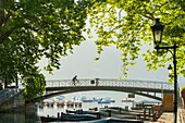 France, Haute Savoie, Annecy, cyclist on the bridge of the Loves at the sunrise and the beginning of the canal du Vasse