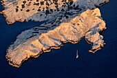 France, Bouches du Rhone, Calanques National Park, Marseille, Riou Archipelago Nature Reserve, Riou Island, Fontagne Point, sailboat in the Calanque de Boulegeade and Fontagne Cove (aerial view)