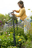 Frau bewässert Sommergarten