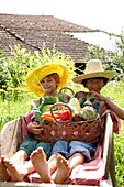 Children holding basket with vegetables