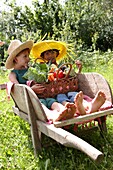 Children holding basket with vegetables