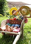 Children holding basket with vegetables