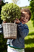 Boy holding shrub