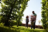 Mann und Kind mit Acer palmatum in der Hand