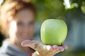 Frau hält Apfel