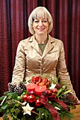 Florist holding christmas arrangement