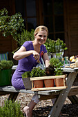 Frau bei der Gartenarbeit mit Kräutern