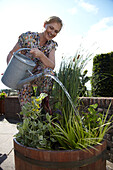 Frau gießt Pflanzen