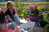 Frau sitzend auf dem Balkon