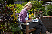 Frau sitzt auf einer Gartenbank