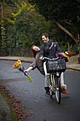 Pärchen fährt Fahrrad und hält Blumen