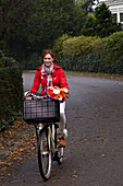 Woman riding bicycle holding flowers