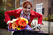 Woman riding bicycle holding flowers