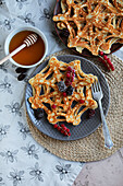 Spider web pancakes with berries and maple syrup