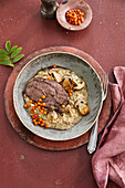 Roast wild boar on porcini mushroom risotto with pickled rowan berries