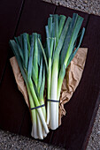 Two bunches of leek on a paper bag