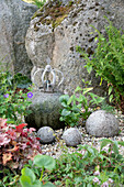 Wasserspiel im Garten mit Storchschnabel (Geranium), Froschlöffel (Alisma), Pfeilkraut, Purpurglöckchen (Heuchera), Farn im Steingarten