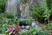 Wasserspiel im Garten mit Storchschnabel (Geranium), Froschlöffel (Alisma), Pfeilkraut, Purpurglöckchen (Heuchera), Farn im Steingarten
