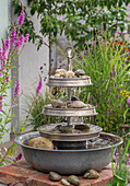 Wasserspiel Etagere, aus alten Zinkschüsseln selber gebaut, neben Gewöhnlichem Blutweiderich (Lythrum salicaria), Sumpf-Schwertlilie und Flatter-Binse