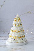 Four-tier pavlova cake with berry filling and mascarpone cream in the shape of a Christmas tree