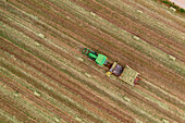 Aerial view of tractor collecting hay bales