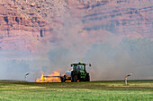 Tractor pulling propane burner in hay field