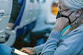 Passenger reading e-reader on flight