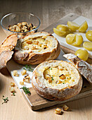 Käse-Kartoffel-Suppe im Brotlaib serviert