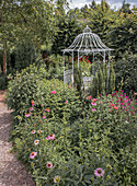 Romantischer Gartenpavillon umgeben von blühenden Stauden