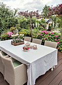 Terrasse mit gedecktem Gartentisch umgeben von Hortensien