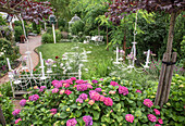 Romantischer Garten mit Hortensien und hängenden Kronleuchtern