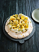 Pavlova with mango and passion fruit sauce and lemon thyme