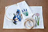 Embroidery hoop and embroidery thread with floral motifs on linen fabric