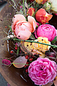 Ranunculus and roses in a rusty bowl