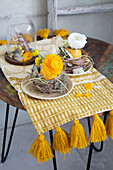 Easter decoration with yellow and white ranunculus on a wooden table