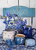 Blue chair with blue and white ceramics and blue flowers