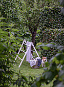 Ladder, laundry basket and dog in the green garden