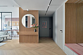 Moderne Wohnungseinrichtung mit Holzelementen und rundem Spiegel, in Warschau