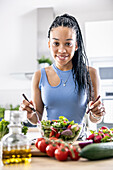 Women's hands mix a healthy spring salad from various ingredients