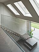 View from the upper floor into the entrance area, staircase with glass balustrade