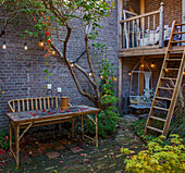 Autumn courtyard with wooden table and lighting