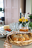 Set table with bread rolls, glass carafe with juice and cheese