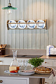 Kitchen island with pastries, plates and fresh herbs in country-style kitchen